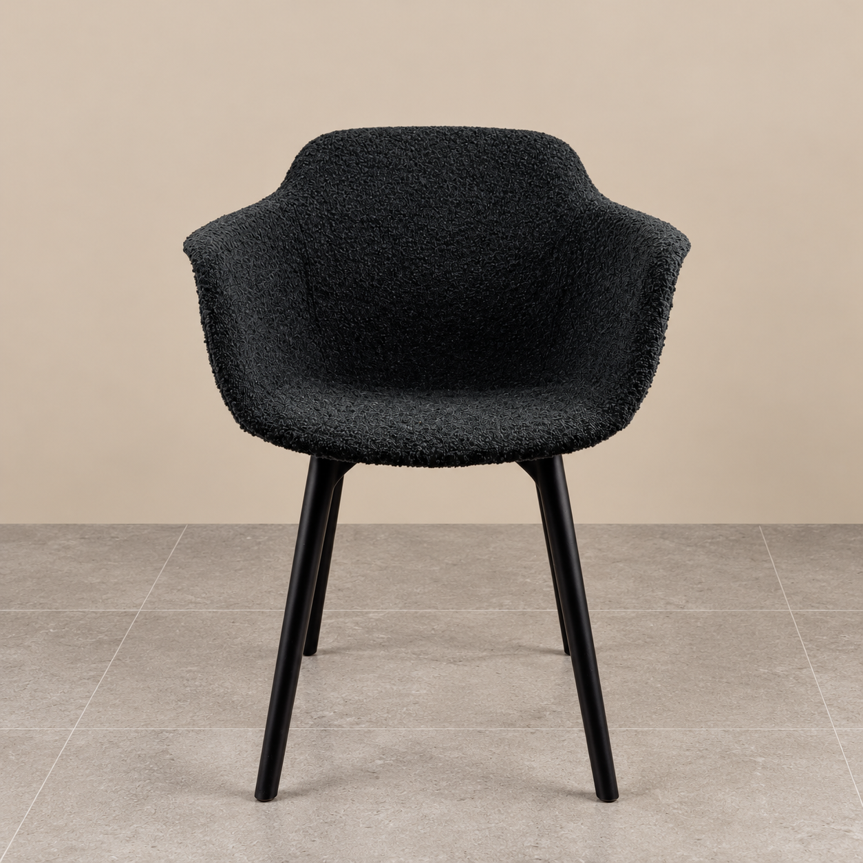 Discover our Black Bouclé Sculptural Dining Chair. Featuring luxurious textured upholstery, curved armrests and sleek black legs for a contemporary look.