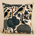 Botanical bird velvet cushion in teal, cream and earthy tones.