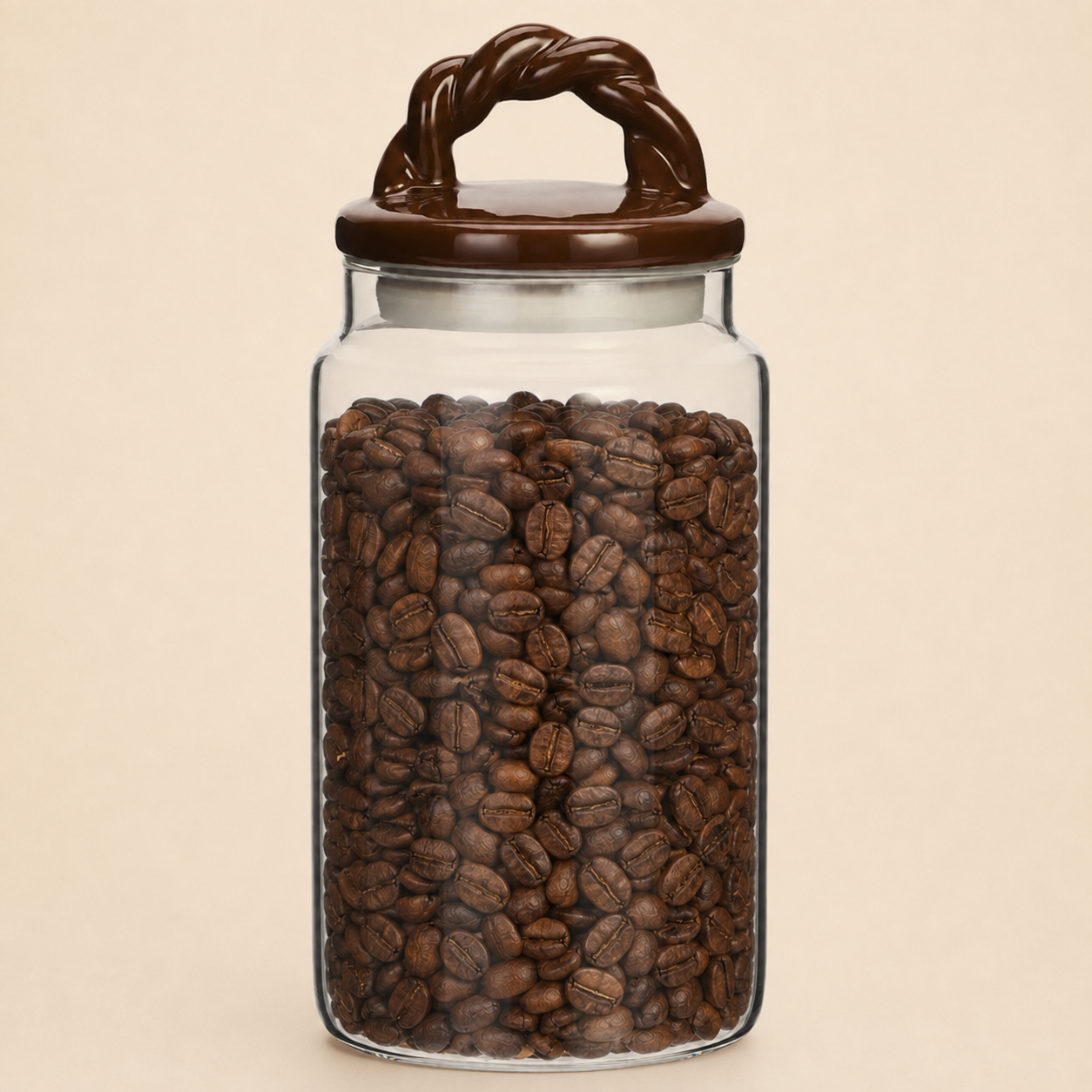 Glass storage jar filled with coffee beans, featuring a brown ceramic braided-handle lid against a warm beige background.