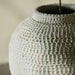 Close-up of the handcrafted textured surface of an extra-large ivory ceramic vase.