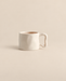 Ivory ceramic mug with a curved sculptural handle on a light beige background.