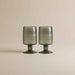 Set of two hand-blown dark green drinking glasses with a distinctive artisan finish.