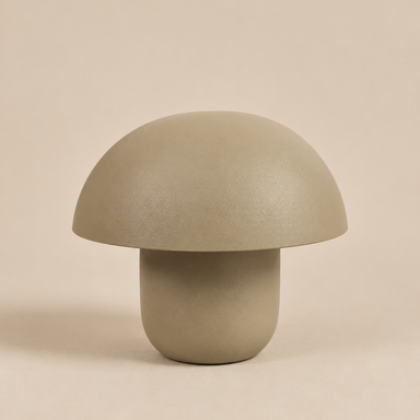 Sculptural mushroom table lamp crafted from metal in a matt taupe finish, featuring an oversized dome-shaped shade and rounded cylindrical base against a warm beige background.