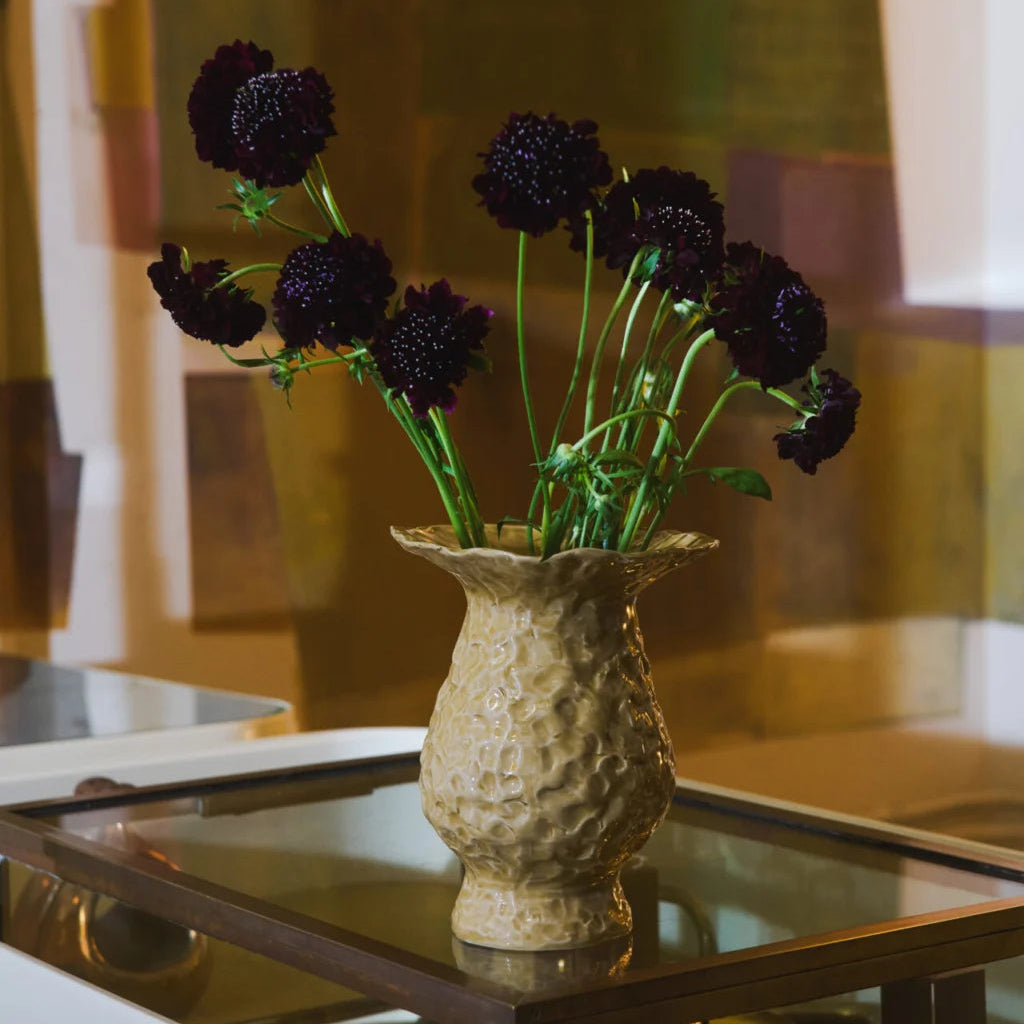 Amber yellow textured glass vase featuring a raised bubble-effect surface, sculptural pedestal base and wide flared wavy rim, photographed against a soft neutral background.