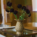 Amber yellow textured glass vase featuring a raised bubble-effect surface, sculptural pedestal base and wide flared wavy rim, photographed against a soft neutral background.
