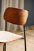 Close-up of the walnut plywood grain and smooth finish on the mid-century dining chair with black metal legs.