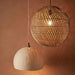 Close-up of the woven rattan craftsmanship and black cord on the natural round pendant light.