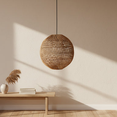 Natural round rattan pendant light with a black cord styled above a dining table in a contemporary home.