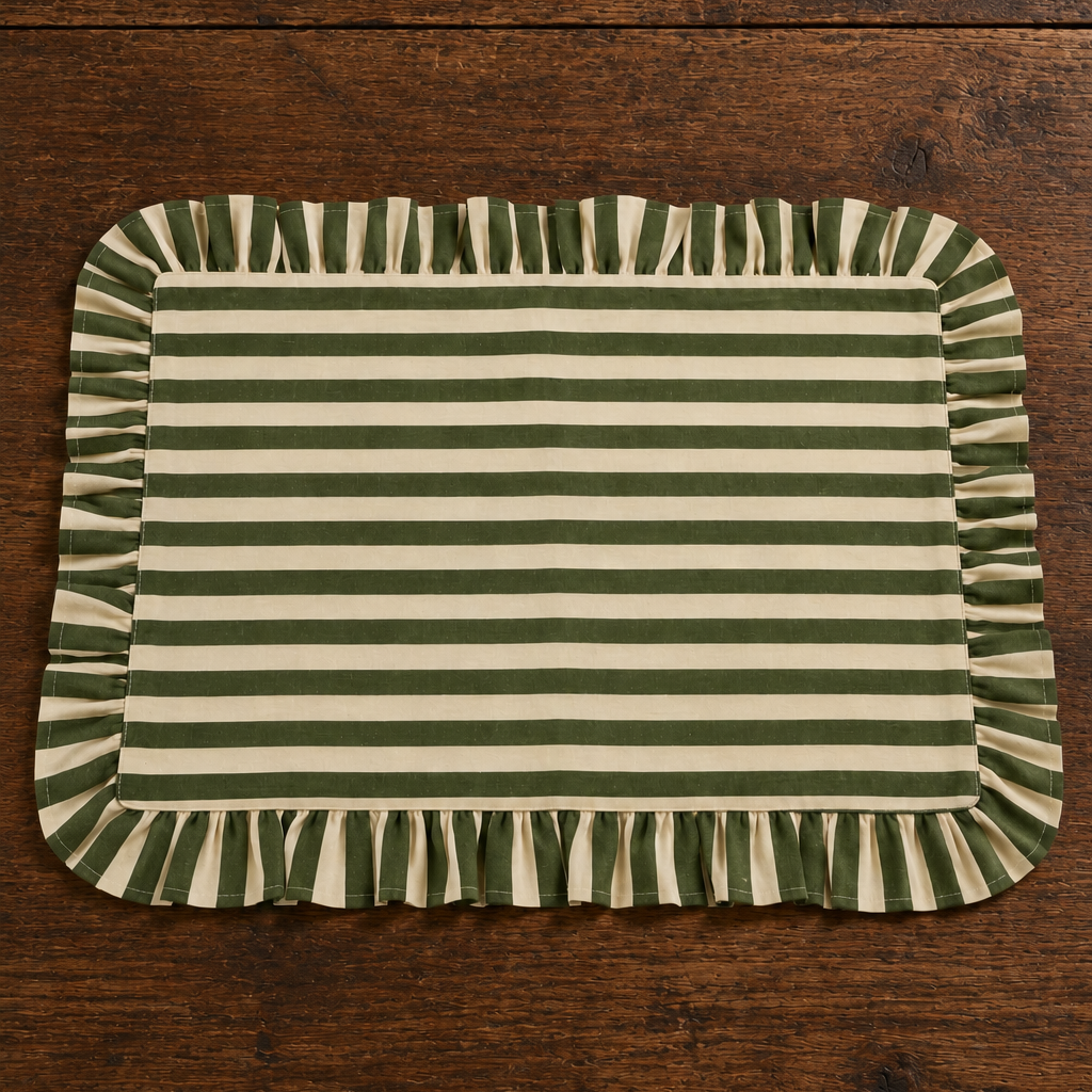 Rectangular olive green and cream striped fabric placemat with a gathered ruffled border, styled on a natural oak dining table.