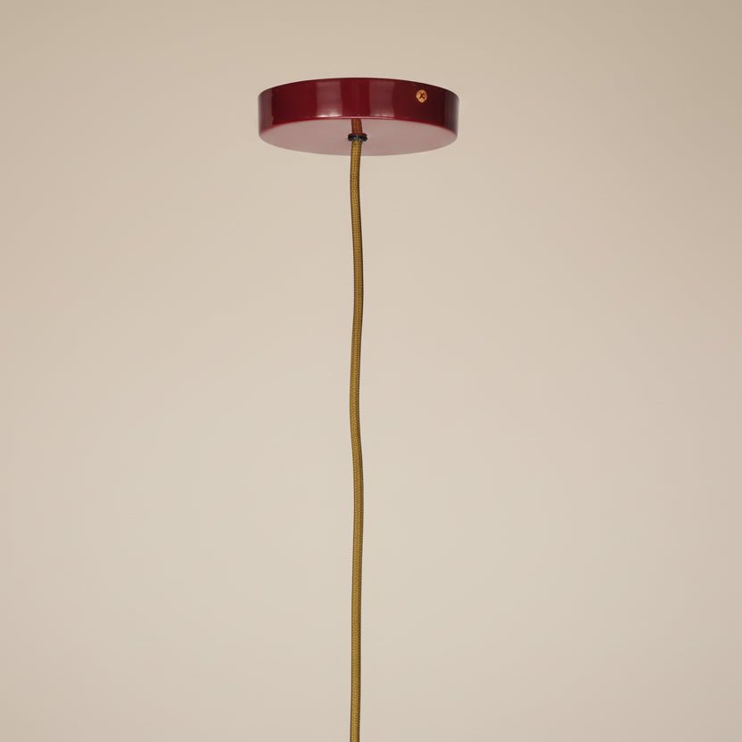 Close-up of the sculptural form and raspberry finish of the contemporary ceiling light.