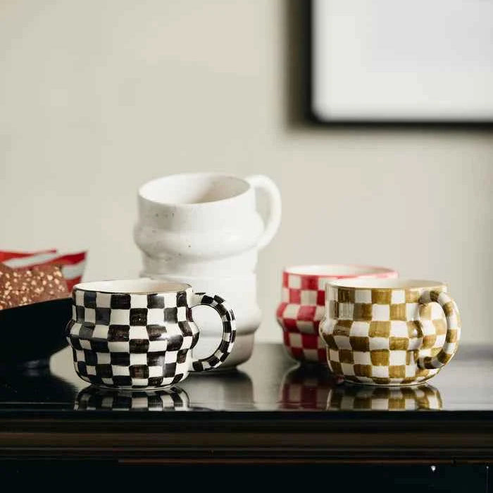 Red and white oval checker mug styled on a contemporary kitchen table with modern home décor.
