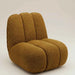 Sculptural mustard boucle sofa chair with soft textured upholstery, curved lines and a contemporary design