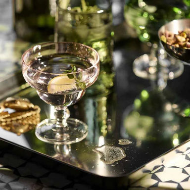 Set of 2 pink Art Deco glasses styled on a contemporary dining table.