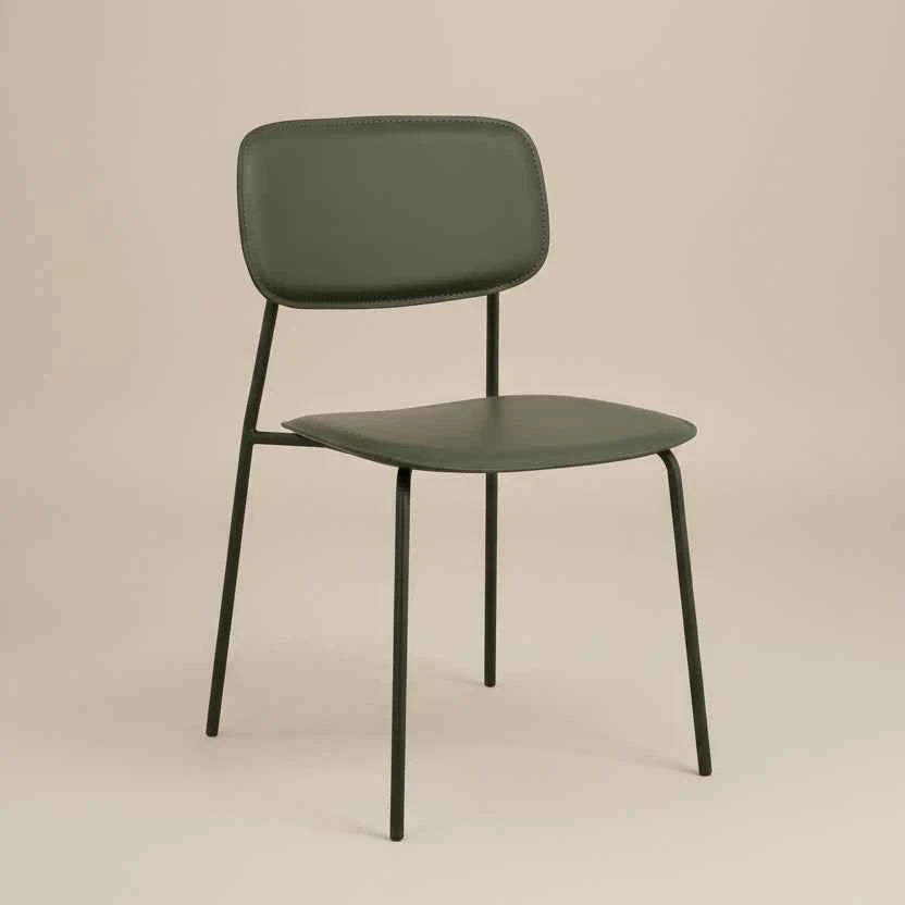 rside profile of a green PU leather dining chair with a cushioned seat, curved backrest and black metal legs.