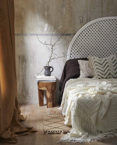 Solid wood three-leg stool styled in a contemporary living space with natural interior décor.