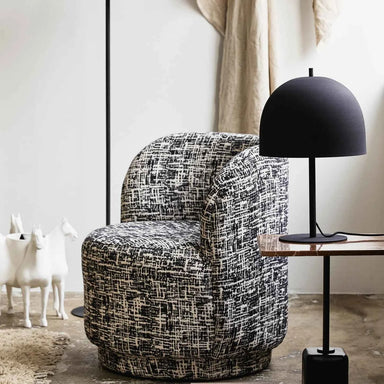 Textured matt black dome side lamp styled on a side table in a contemporary living room.