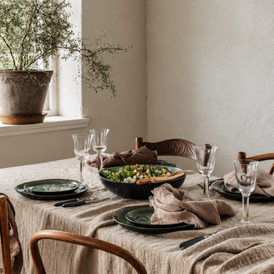 Set of two vintage-inspired clear glass goblets with elegant flared rims and slender stems, photographed together against a warm beige background.